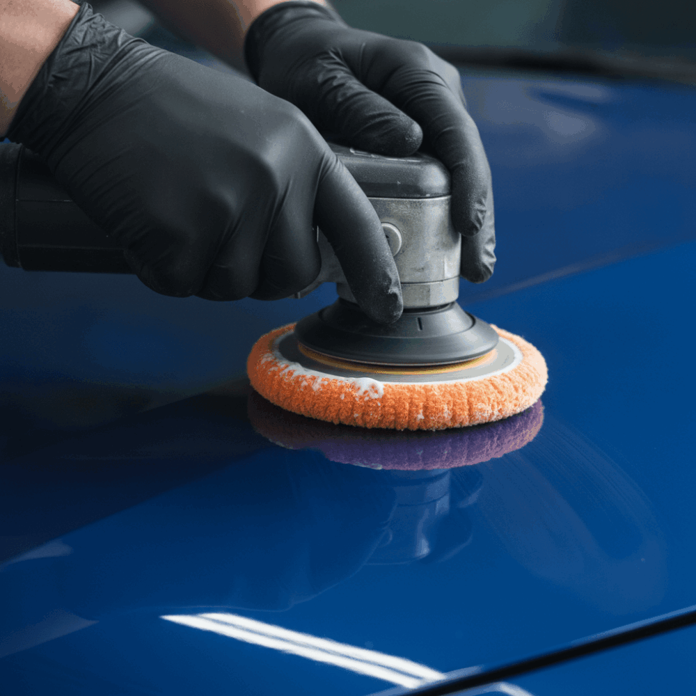 Professionnel certifié effectuant un polissage de carrosserie avec machine rotative sur véhicule