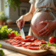 Femme enceinte en cuisine préparant un plat avec du chorizo