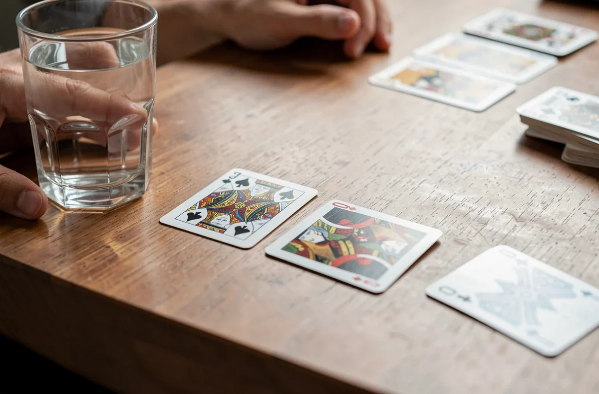 Joueurs de cartes autour d'une table avec quatre cartes au centre